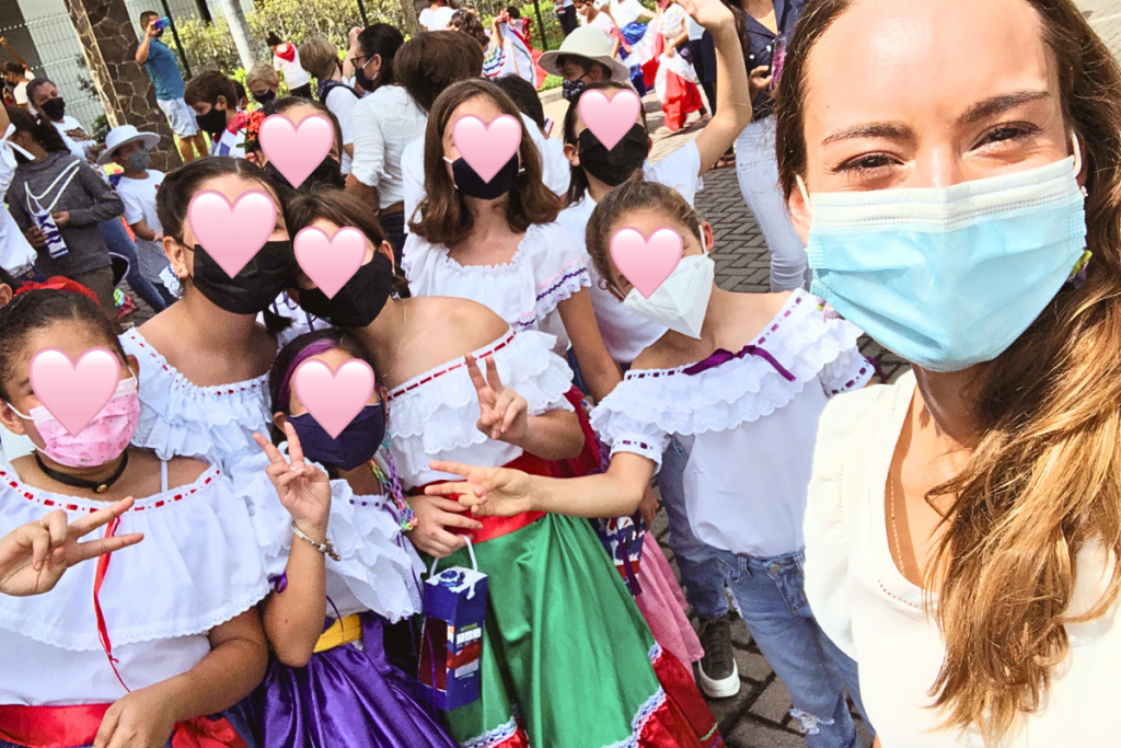 Students in traditional Costa Rican clothes posing with their teacher at an international school.